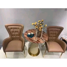 Fauteuil en cuir rembourré, avec coutures décoratives, coussinets de pieds et pieds en laiton, noir et chocolat.