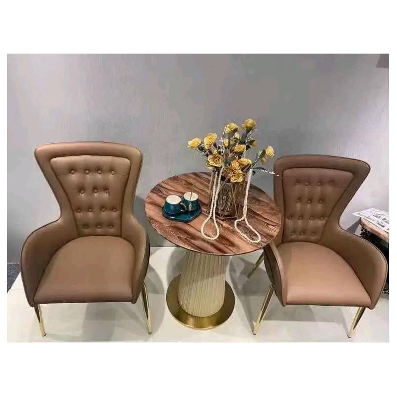 Fauteuil en cuir rembourré, avec coutures décoratives, coussinets de pieds et pieds en laiton, noir et chocolat.